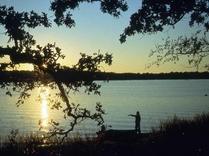 sunset on lake, angler on shore