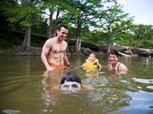 family swimming in river