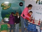 children and woman looking at exhibits