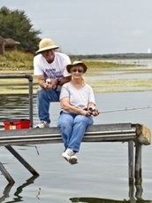 couple fishing on lake pier