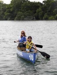 woman and girl paddling a canoe