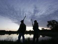 2 hunters at dusk along marsh