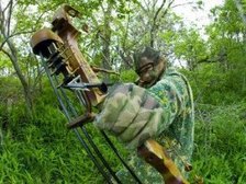 bowhunter in camo taking aim