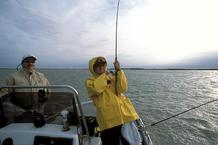 open sea, angler in boat, fish on line