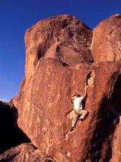 man climbing rock face, no ropes
