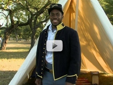 Buffalo soldier standing by tent, smiling