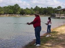man and child fishing at city pond