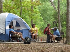 family sitting around tent