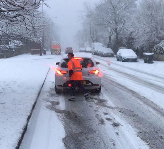 bin staff helping a car get going in the snow
