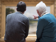Couple sitting in a gallery, looking at a painting