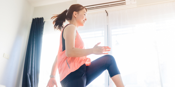 Lady dressed in sports attire, doing a dance exercise