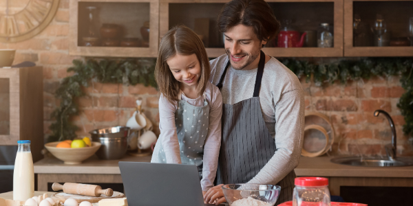 man and child cooking together with laptop