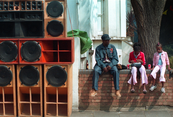 People sitting on a wall beside a soundsystem