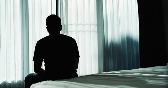 man sat on edge of bed