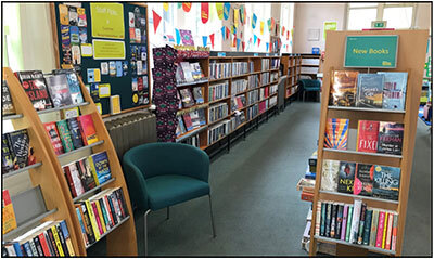 Interior of Heckmondwike Library, shelves of books and bright bunting