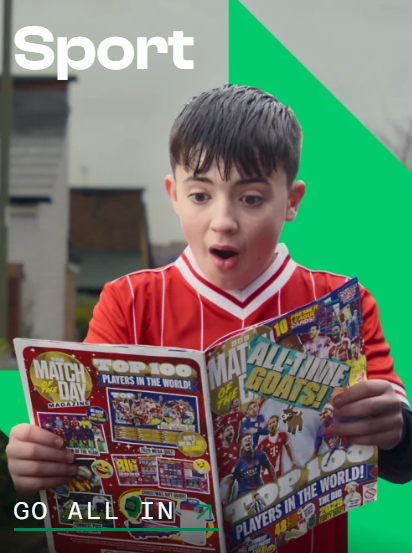 Image of boy in sports kit enjoying reading a sport magazine