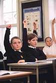 primary school class with boy with hand in air