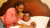 mother measuring fever on child