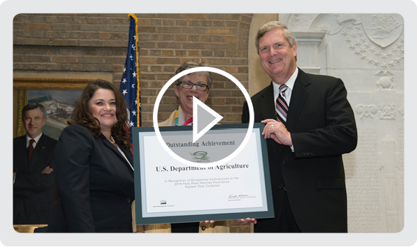 2015 Feds Feed Families National Program Manager Jennifer McDowell and Agriculture Secretary Tom Vilsack presenting an Award to USDA Research, Educati