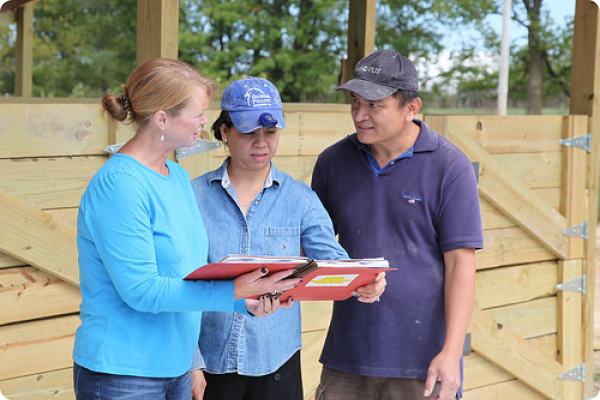 Rhonda Foster, Washington County, Ark., district conservationist, meets with Diem and Bruce Norindr on their poultry farm to discuss the operation’s n