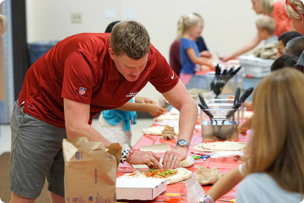 Arizona Cardinals football player Drew Butler makes pizza with kids at the Ken "Chief" Hill Learning Academy of the Chandler Unified School District i