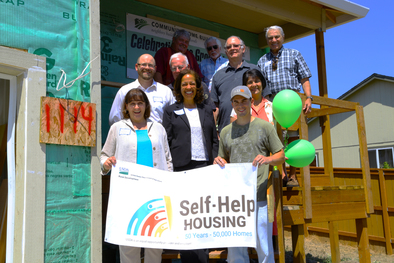 Photo of Under Secretary Mensah, State Director Walker, and local officials celebrating the 50,000th home built through the Mutual Self-Help Program