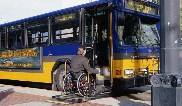 Man in wheelchair boards a transit bus