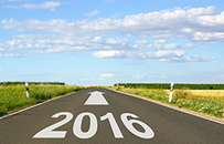 A photo of a road with 2016 painted on it and an arrow pointing towards the horizon.