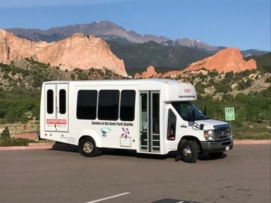 A Garden of the Gods shuttle shown in the parking lot.