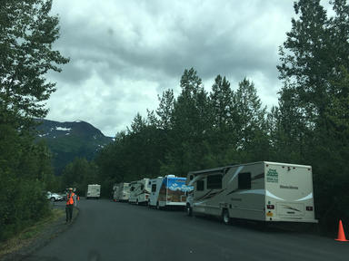 RVs sit in a parking lot alongside the edge of the road.