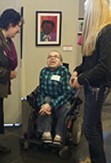 student in wheelchair showcasing his artwork