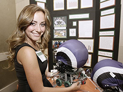 Young female standing in front of experiment.