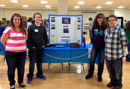 Students stand in front of presentation