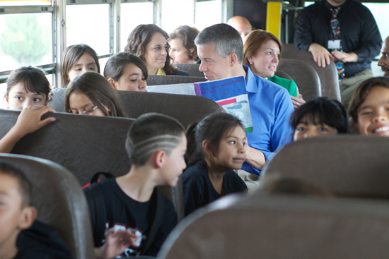 Secretary Duncan reading to students on bus