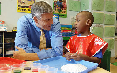 Secretary Duncan talking to young student.