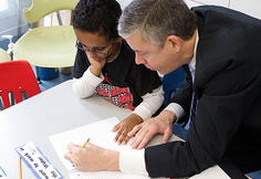 Secretary Duncan helping a student with school work. 