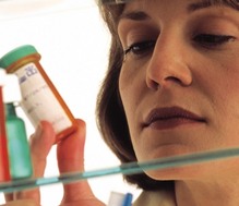 Woman looking at a pill bottle