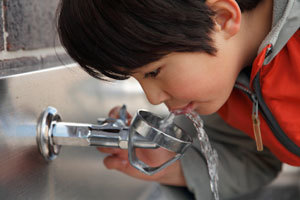 Boy drinking from water fountain