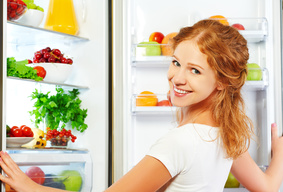 Woman stocking refrigerator