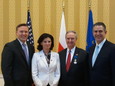 Jay Burgess (second from right) recieves the Order of Merit of the Republic of Poland with Adam Wilczewski (left), Vice Minister of State for the Mini