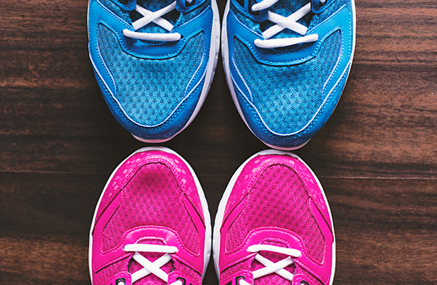 A pair of blue sneakers above a pair of pink sneakers.