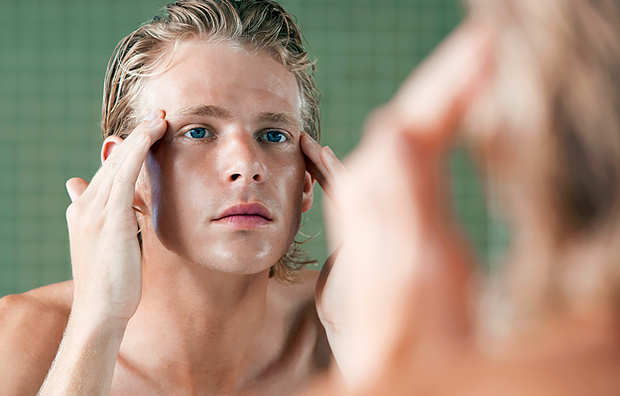 A man applying a petrolatum-free skin product to his face.