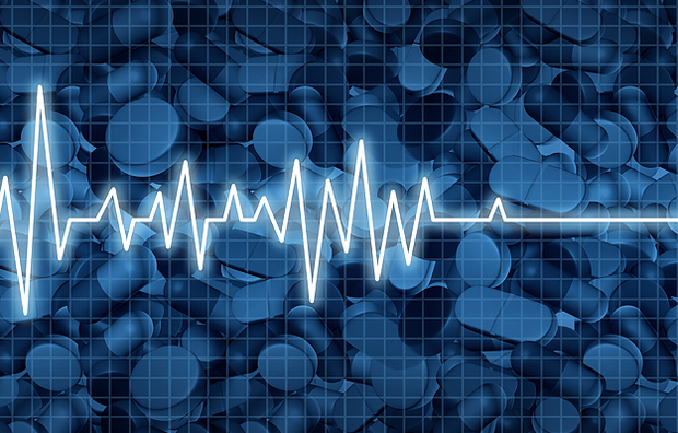 An illustration of an electrocardiogram of cardiac arrest on a background of pills.