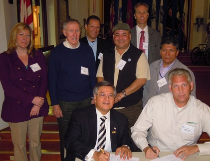 Photo: Elite SDVOB board members watch as Ruben Garcia and Gregg Torwick sign Strategic Alliance Memorandum