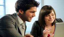 Male and female working together in front of a laptop