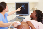 A nurse and a mother look at an ultrasound screen.