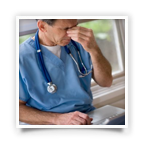 Image of a male medical professional with hand over eyes expressing fatigue.