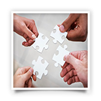 Four hands manipulating four individual puzzle pieces