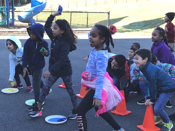 Photo of children playing a bean bag toss game.