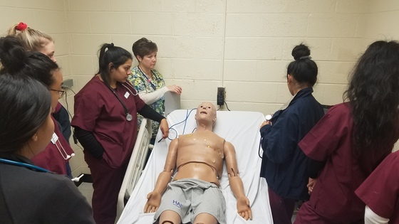 picture of students around simulation maniquin 